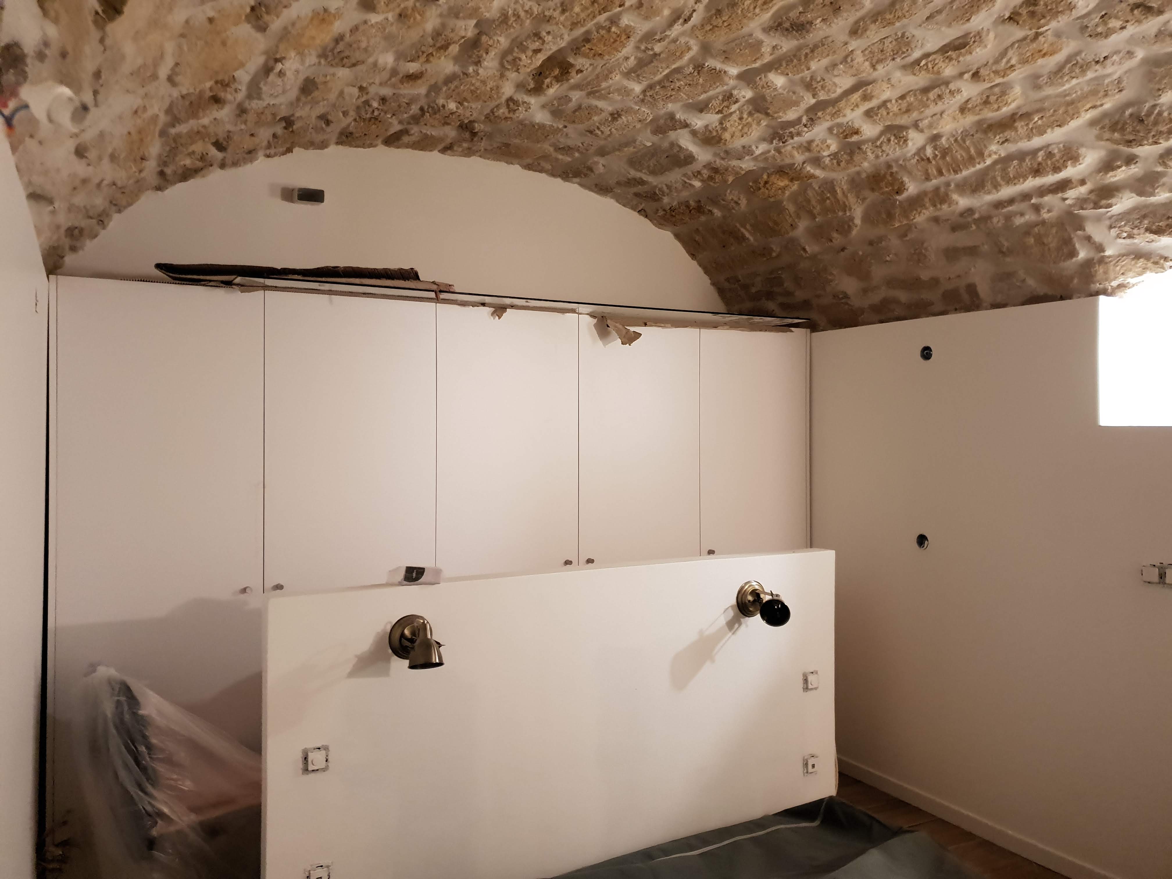 Aménagement de la cave en cours : cloisons, placards et électricité sous la voûte en pierre