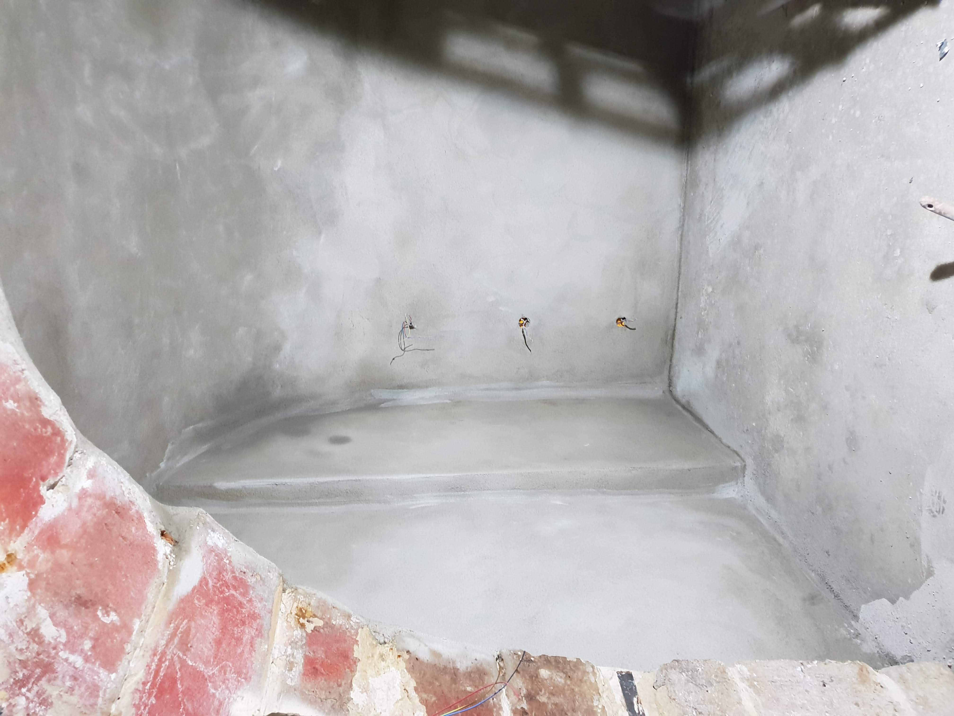 Cuvelage de la cave : murs et sol enduits d'un mortier d'étanchéité pour la mise hors d'eau