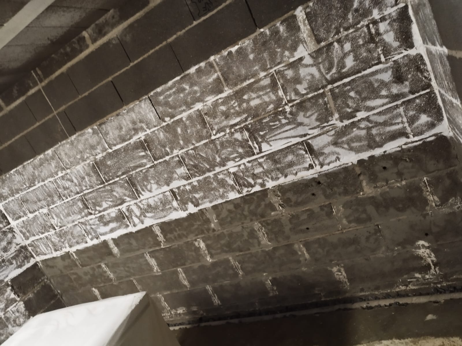 Mur en parpaings d'un sous-sol à Olivet couvert de salpêtre et de traces d'infiltration d'eau de pluie