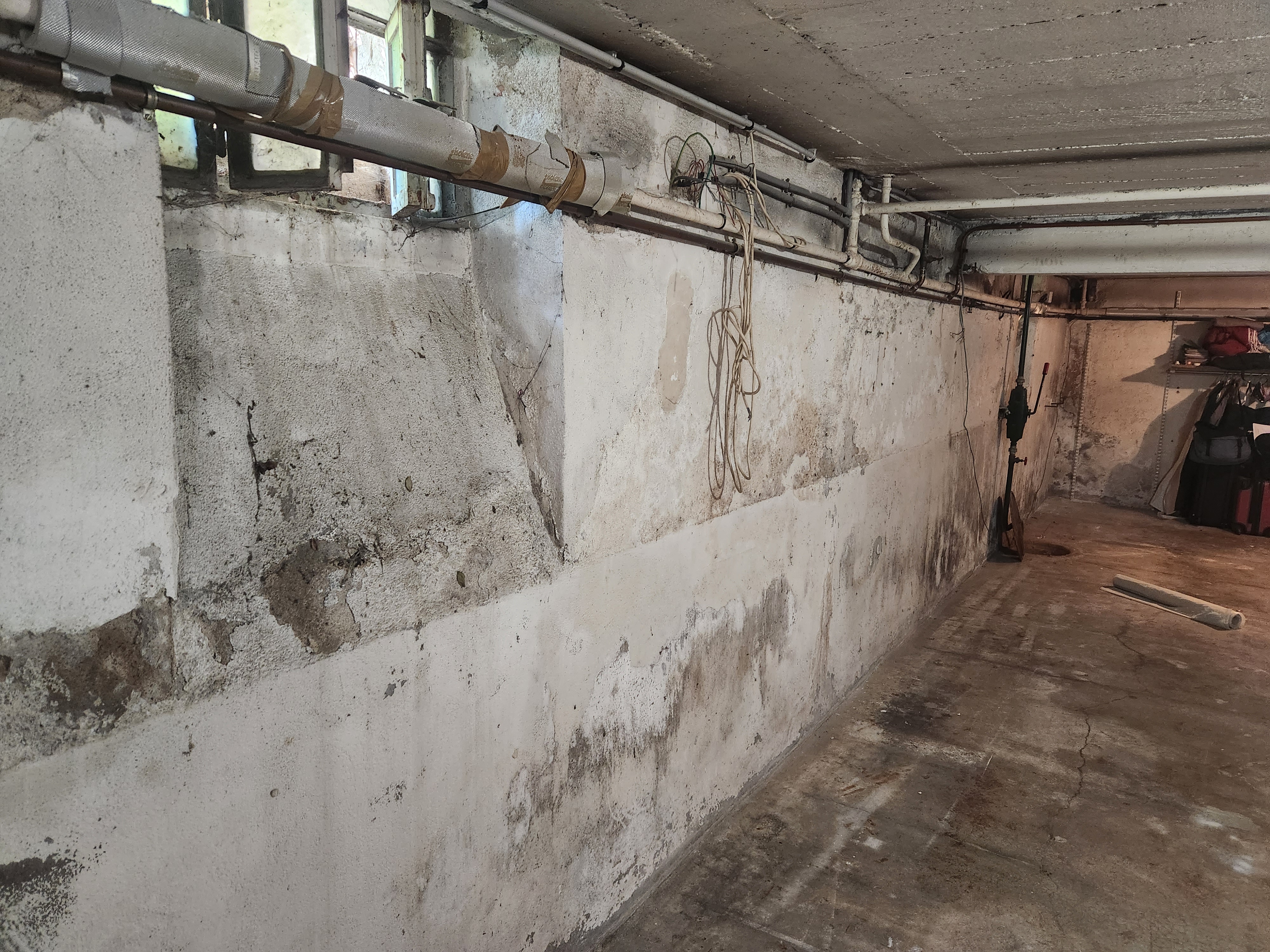 Sous-sol d'une maison bourgeoise à Orléans avant travaux : murs marqués par l'humidité et les remontées en partie basse