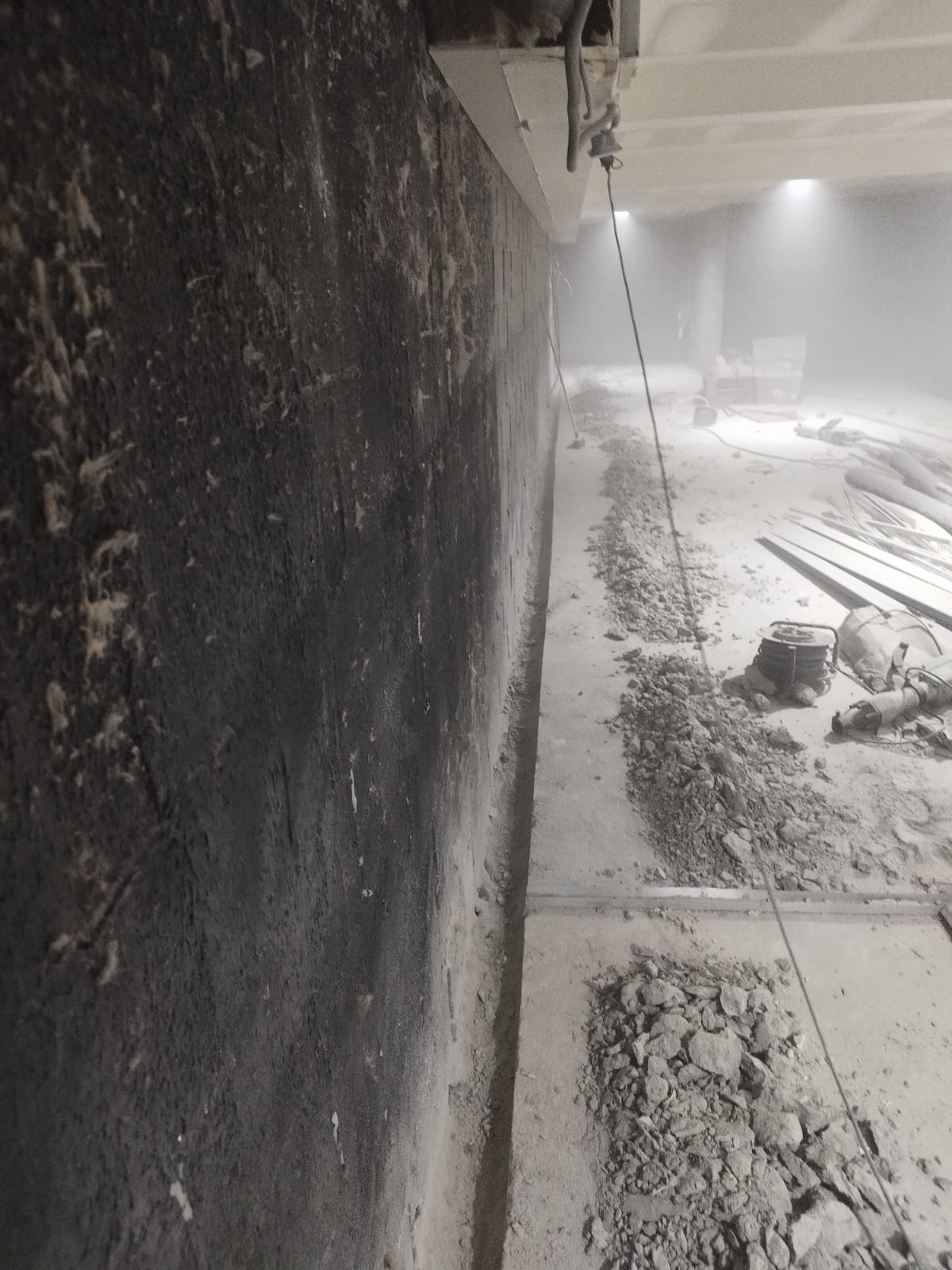 Mur de sous-sol d'une maison neuve à Orléans recouvert de goudron noir par le constructeur, sol décaissé pour les travaux
