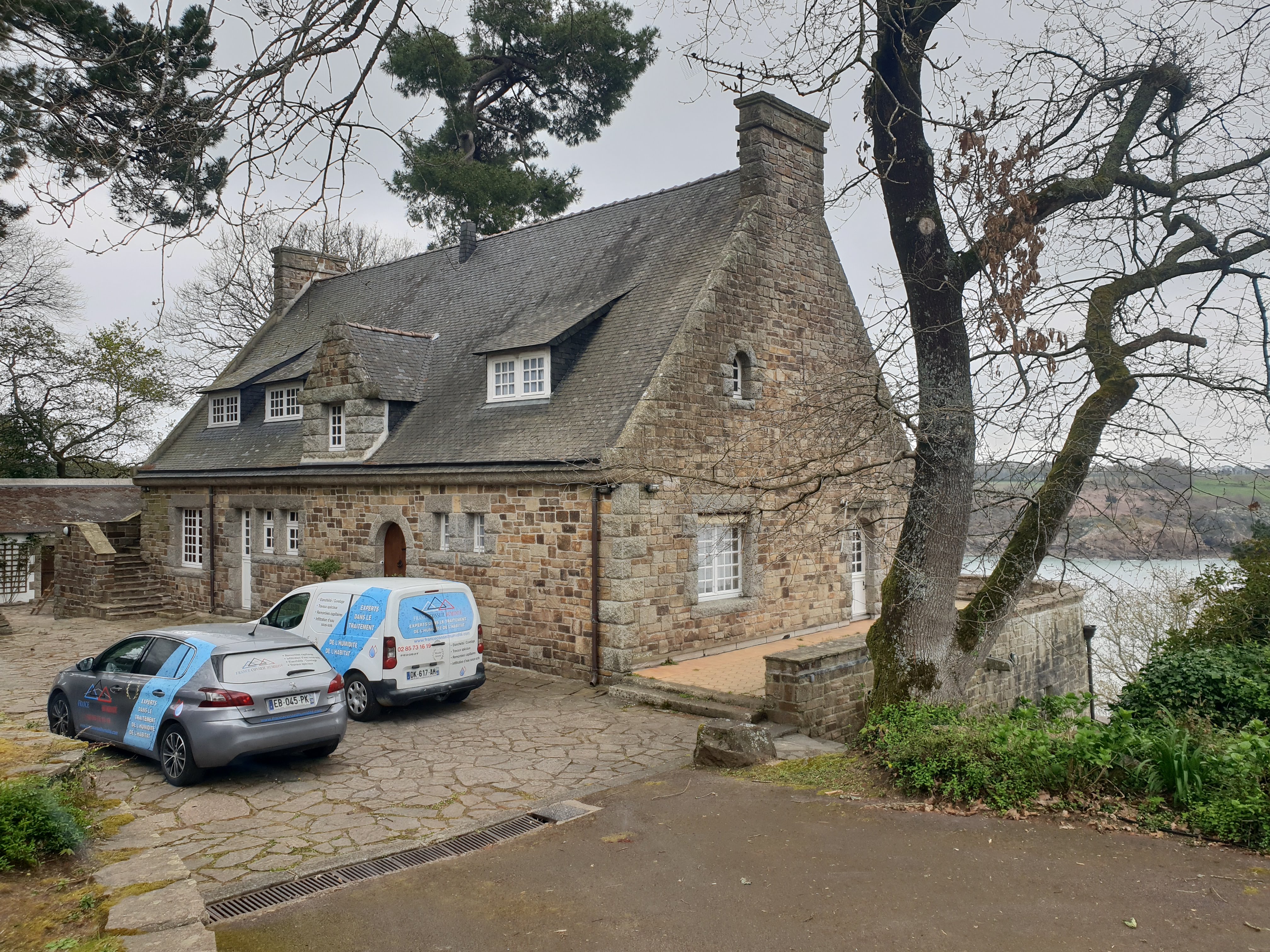 Manoir breton en pierre au bord de l'eau, véhicules France Conseil Humidité sur place