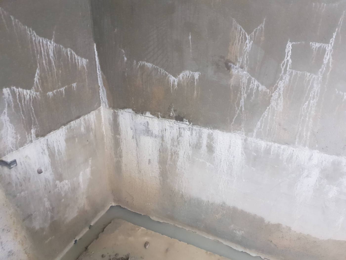 Murs d'une pièce technique enterrée à Santeny marqués par l'eau stagnante et le salpêtre, avant travaux