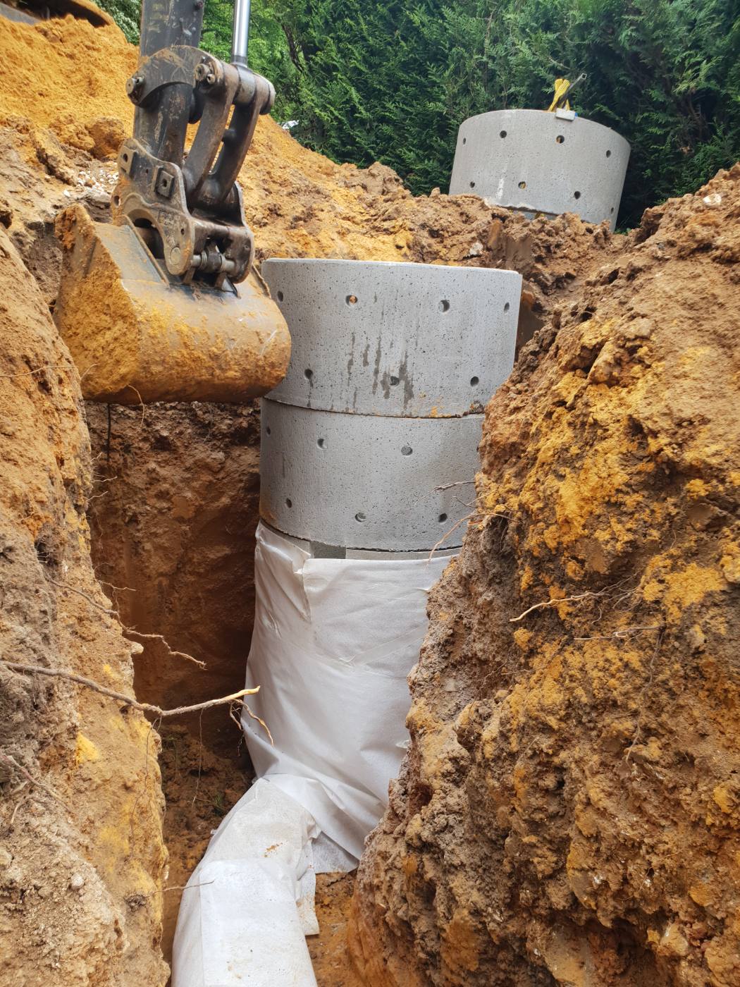 Pose d'un regard collecteur avec pompe de relevage dans la tranchée de drainage à Santeny